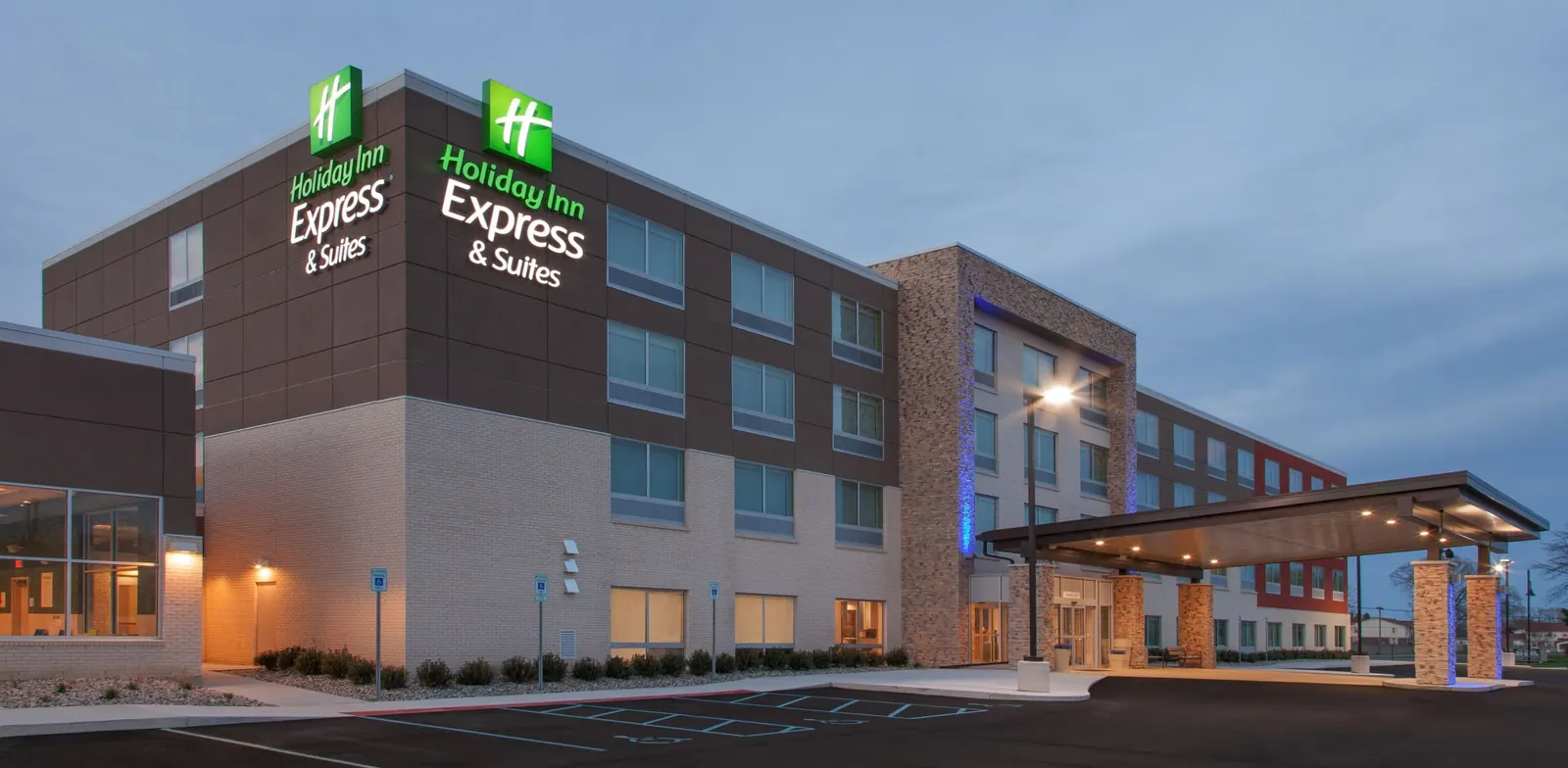 Holiday Inn Express & Suites hotel exterior in Sterling Heights, Michigan, a four-storey brick and stucco building with a covered entry drive